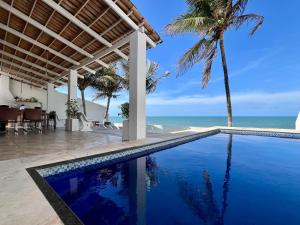 a swimming pool with a view of the ocean at Casa La France in Caucaia