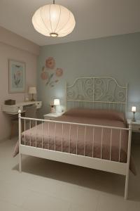 a bedroom with a bed and a chandelier at Colorful House Tsoutsouras in Tsoutsouros