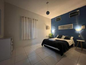 a bedroom with a bed and a blue wall at Casa La France in Caucaia