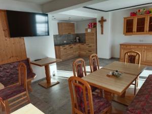 a kitchen with a wooden table and chairs and a television at Pension Essbaum in Walchsee +36 photos