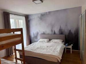a bedroom with a bed with a painting on the wall at Kovárna Residence in Pec pod Sněžkou