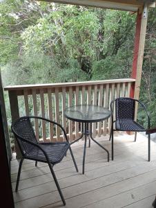 a table and two chairs on a porch at Rata Lodge Accommodation in Otira