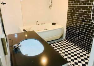 a bathroom with a tub and a toilet with a mirror at เคทูกรีน สุพรรณบุรี in Ban Hua Phrong