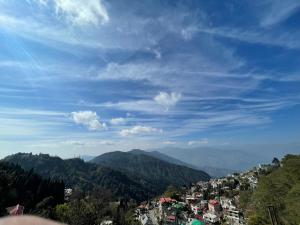 a view of a town on a hill with mountains at Mandira Homestay in Jālāpahār