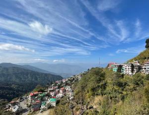 a view of a town on a hill with buildings at Mandira Homestay in Jālāpahār