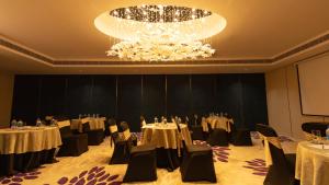 a conference room with tables and chairs and a chandelier at Coral Reef Kakkanad in Cochin