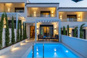 a villa with a swimming pool in front of a house at Kara Villas in Kallithea Halkidikis
