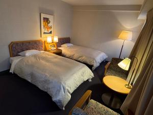 a hotel room with two beds and a table at Ohta Grand Hotel in Ota