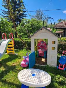 a toy house with a play room in the grass at Дядо Цоньовата къща самостоятелен имот с басейн in Sevlievo