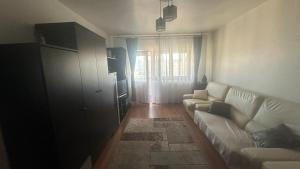 a living room with a white couch and a window at 2 Rooms Center Ramnicu Valcea in Râmnicu Vâlcea