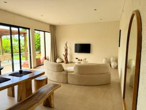 a living room with a white couch and a television at Villa YAOUH à Seseh in Munggu