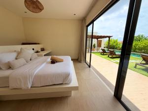 a bedroom with a bed and a sliding glass door at Villa YAOUH à Seseh in Munggu +28 photos