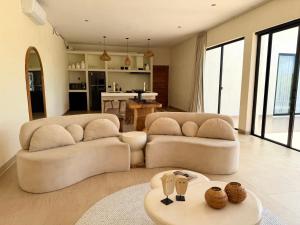 a living room with two couches and a kitchen at Villa YAOUH à Seseh in Munggu