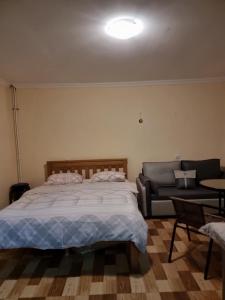 a bedroom with a large bed and a couch at Mia House in Borjomi