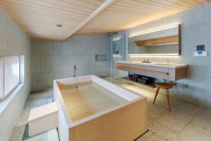 a large bathroom with a tub and a sink at 季楽 邸 清水 Kiraku Tei Kiyomizu in Kyoto
