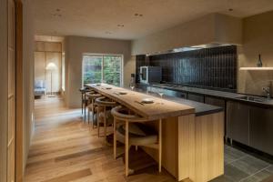 a kitchen with a long island with a table and chairs at 季楽 邸 清水 Kiraku Tei Kiyomizu in Kyoto +21 photos
