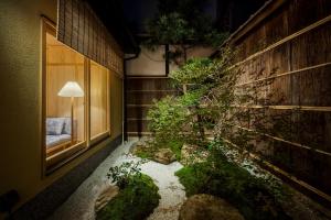 a garden in a room with a lamp next to a building at 季楽 邸 清水 Kiraku Tei Kiyomizu in Kyoto