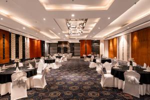 a banquet hall with tables and white chairs at Pal Heights Mantra in Bhubaneshwar +144 photos