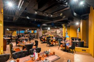 a restaurant with tables and chairs and lights at Pal Heights Mantra in Bhubaneshwar