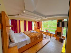 a bedroom with a large bed and a television at Rozana Retreats Ooty in Ooty