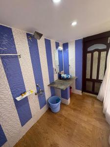 a bathroom with blue and white stripes on the wall at Rozana Retreats Ooty in Ooty