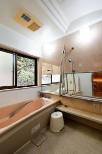 a bathroom with a large tub and a window at ゲストハウス nagatafure in Iki +37 photos