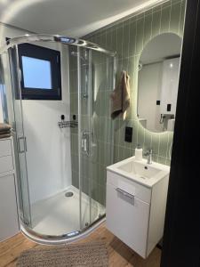 a bathroom with a shower and a sink and a mirror at Pniówek Chill in Zamość +16 photos
