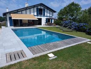 a swimming pool in front of a house at Fleurs in Bassussarry