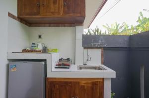 a small kitchen with a sink and a refrigerator at Rumah Kecil kesari in Denpasar +9 photos
