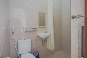 a bathroom with a toilet and a sink at Rumah Kecil kesari in Denpasar
