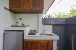 a small kitchen with a sink and a refrigerator at Rumah Kecil kesari in Denpasar