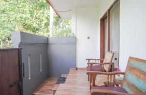 a porch with chairs and a table and a window at Rumah Kecil kesari in Denpasar