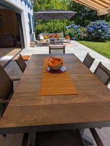a wooden table with a bowl of fruit on it at Fleurs in Bassussarry +19 photos