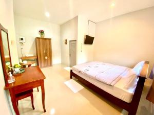 a small bedroom with a bed and a desk at ลียา รีสอร์ท in Ban Bang Mak (1)