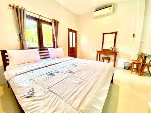 a bedroom with a large white bed with a window at ลียา รีสอร์ท in Ban Bang Mak (1) +15 photos