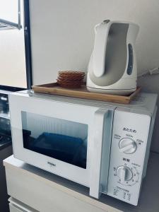 a microwave and a toaster sitting on top of a counter at 宿えんがわーおもや in Tokorozawa
