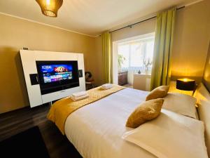 a bedroom with a large bed and a flat screen tv at Zuzu’s home in Râşnov