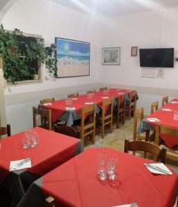 a dining room with red tables and chairs at Pensione Aurora in Imperia