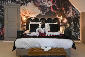 a bedroom with a bed with two white shoes on it at Domaine de Suzel Hôtel & Spa in Vignieu
