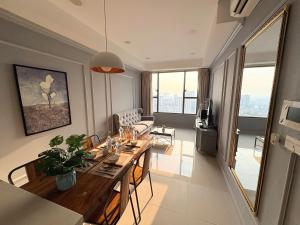 a dining room and living room with a table and chairs at Dear You, Apartment! Saigon - Rivergate Building in Ho Chi Minh City