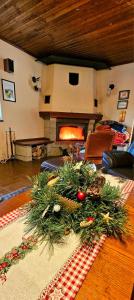 a living room with a christmas tree on a table with a fireplace at Chata Bella in Smižany
