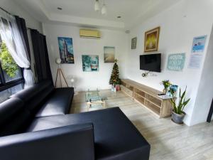 a living room with a black couch and a christmas tree at D&A Paradise Villas in Koh Samui