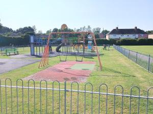 a playground in a park behind a fence at Bideawee in Belton