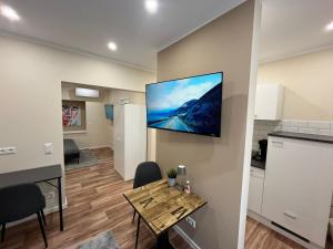a living room with a table and a tv on a wall at Lumio Apartment 3 - Klimatisiert - Coffee for free - in Karlsruhe +15 photos