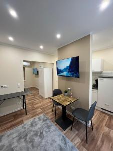 a living room with a table and chairs and a kitchen at Lumio Apartment 3 - Klimatisiert - Coffee for free - in Karlsruhe