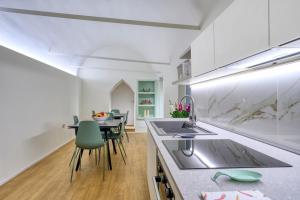a kitchen and dining room with a table and chairs at Le Stanze Del Savonarola in Ferrara