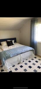 a bedroom with a bed with a blue and white floor at Lillhuset Gallerud in Årjäng