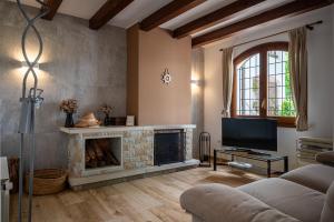 a living room with a fireplace and a tv at AT084 Piscina compartida con 3 casas y vistas al mar in Torredembarra +28 photos