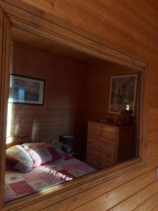 a mirror in a bedroom with a bed and a dresser at La Moraine in Villard-de-Lans