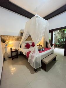 a bedroom with a bed with a mosquito net at Penida Dream Homestay and hostel in Nusa Penida